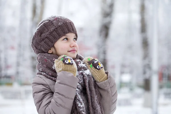 Glückliches kleines Mädchen auf dem Hintergrund eines Winterparks — Stockfoto