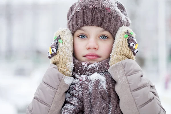 Glückliches kleines Mädchen auf dem Hintergrund eines Winterparks — Stockfoto