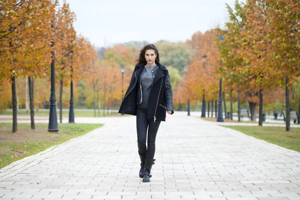 Szczęśliwa kobieta w czarnym płaszczu ulicy walking street jesień — Zdjęcie stockowe