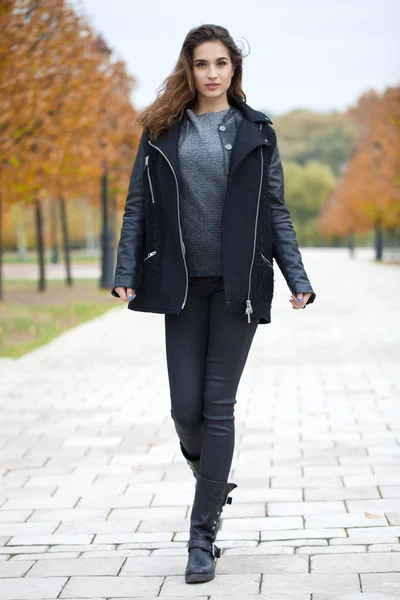 Happy woman in black coat walking autumn street — Stock Photo, Image