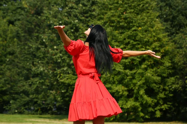 Joyeux jeune femme en robe rouge — Photo