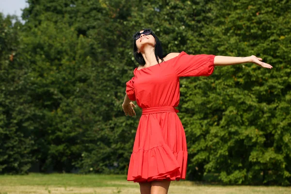 Joyeux jeune femme en robe rouge — Photo