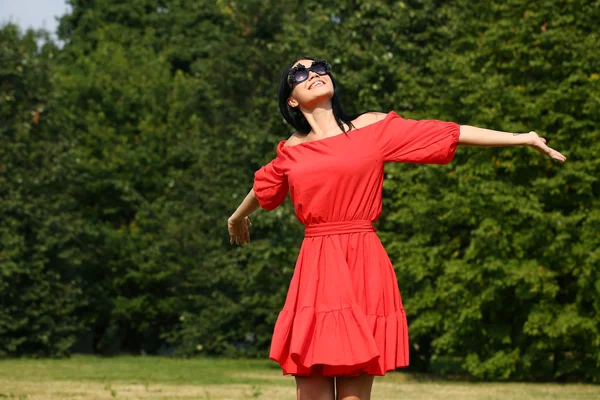 Счастливая молодая женщина в красном платье — стоковое фото