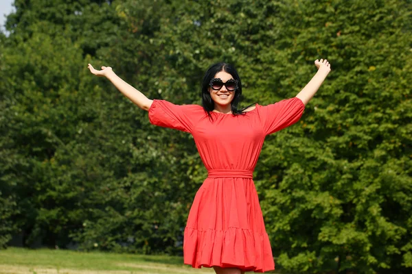 Счастливая молодая женщина в красном платье — стоковое фото