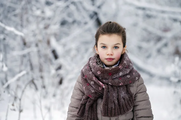 Ragazzina felice sullo sfondo di un parco invernale — Foto Stock