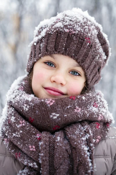 Happy little girl on the background of a winter park Stock Image
