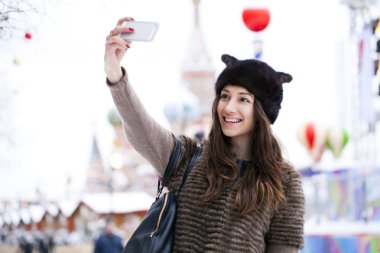 Genç güzel kadın turist üstünde hareket eden telefon fotoğraf çekmek