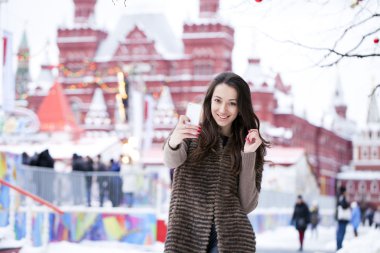 Genç güzel kadın turist üstünde hareket eden telefon fotoğraf çekmek