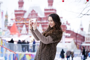 Genç güzel kadın turist üstünde hareket eden telefon fotoğraf çekmek