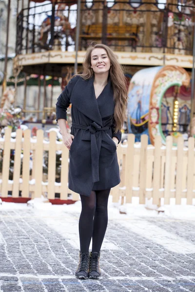 Glückliche junge Frau mit braunen Haaren auf dem Hintergrund eines Winteramus — Stockfoto