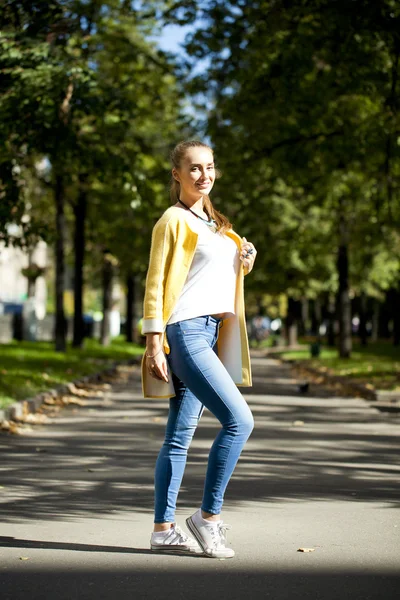 Mulher feliz no casaco amarelo andando rua outono — Fotografia de Stock