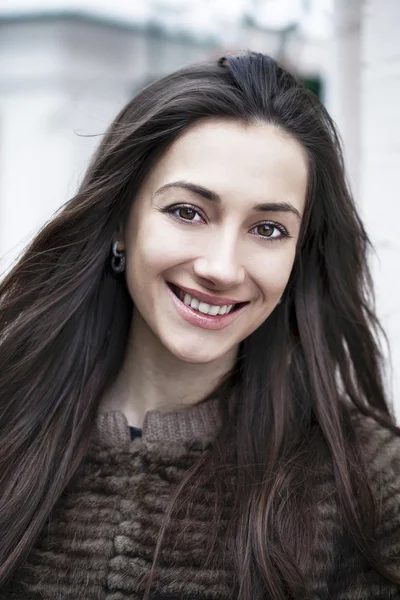 Jovem mulher bonita feliz em um contexto de uma rua de inverno — Fotografia de Stock