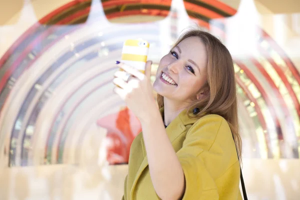 Glad ung kvinna läser ett meddelande på telefonen — Stockfoto