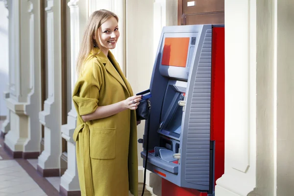 Blonde lady using an automated teller machine — Stock Photo, Image