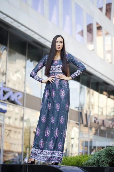 Beautiful young woman in colorful dress — Stock Photo, Image