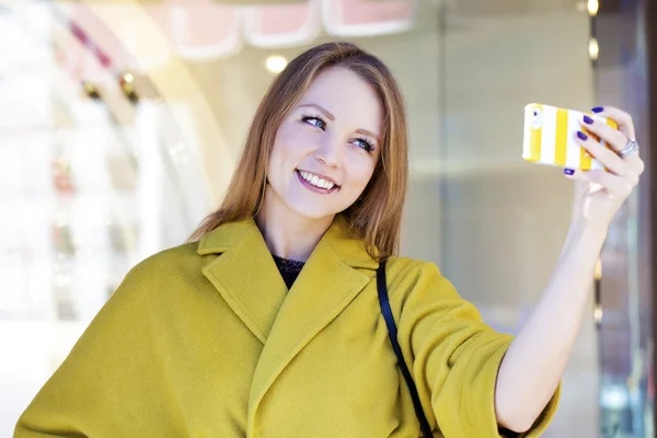 Happy young woman reading a message on the phone — Stock Photo, Image