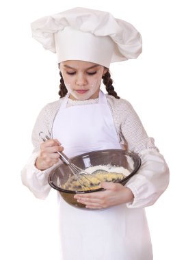 Küçük kız cook fırçalamak yumurta büyük bir tabak içinde kamçı.