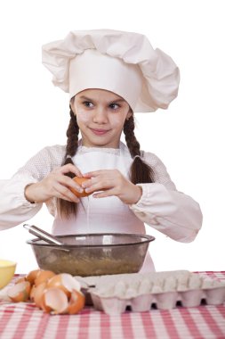 Küçük aşçı kız beyaz bir önlük yumurtaları derin bir tabak içinde tatili.