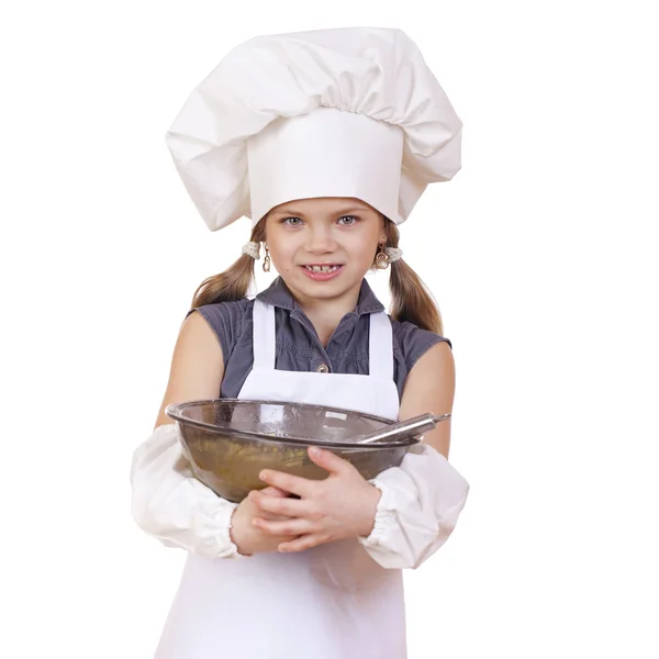 Kleine Köchin schlägt Schneebesen-Eier in einem großen Teller — Stockfoto