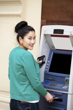 Asya Bayan bir otomatik vezne makinesi kullanma 