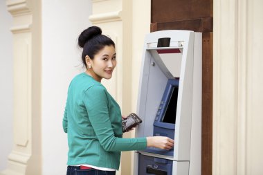 Asya Bayan bir otomatik vezne makinesi kullanma 