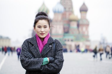 Bir re üzerinde gri paltolu güzel genç Asyalı kadın portresi