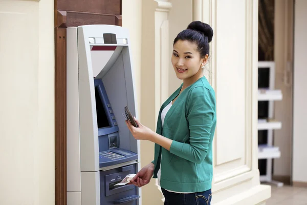 Asiatische Dame mit einem Geldautomaten — Stockfoto