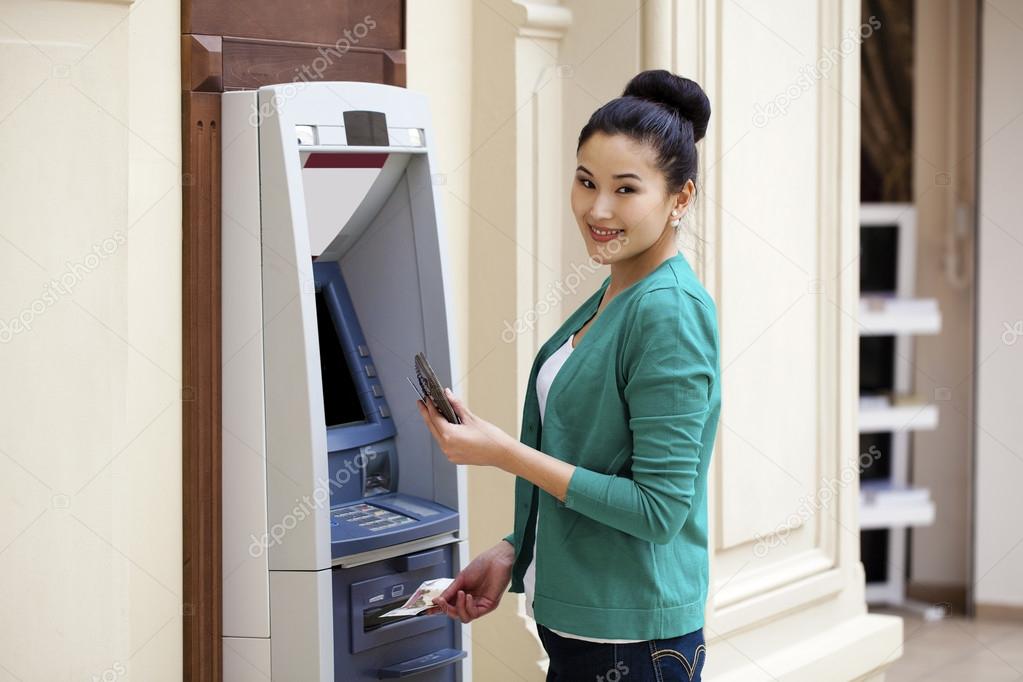 Asian lady using an automated teller machine 
