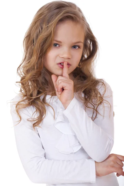 Küçük kız işaret parmağı dudaklar için sessizlik işareti olarak koymuştur — Stok fotoğraf