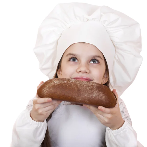 Маленькая девочка в шляпе повара смотрит вверх — стоковое фото
