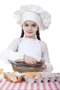 Küçük aşçı kız beyaz bir önlük yumurtaları derin bir tabak içinde tatili.