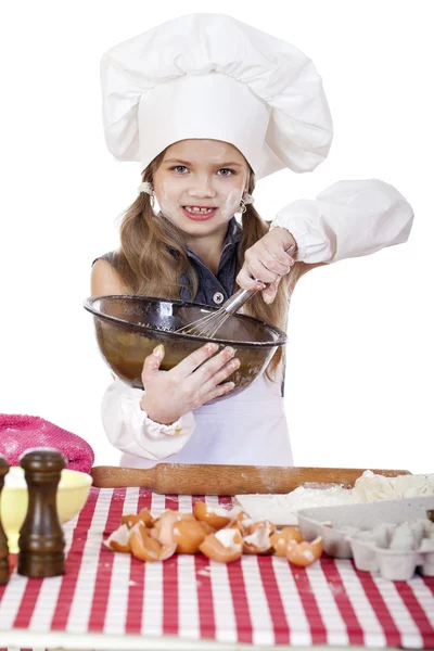 少し女の子料理は大きなプレートで卵をかき混ぜるを鞭します。 — ストック写真