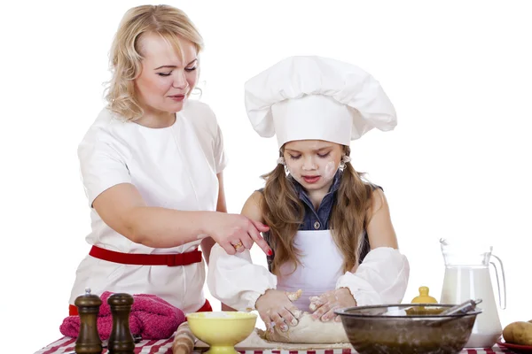 Kleines Mädchen hilft ihrer Mutter bei der Zubereitung eines Kuchens — Stockfoto