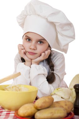 Güzel küçük şef tencere sebze ile masaya