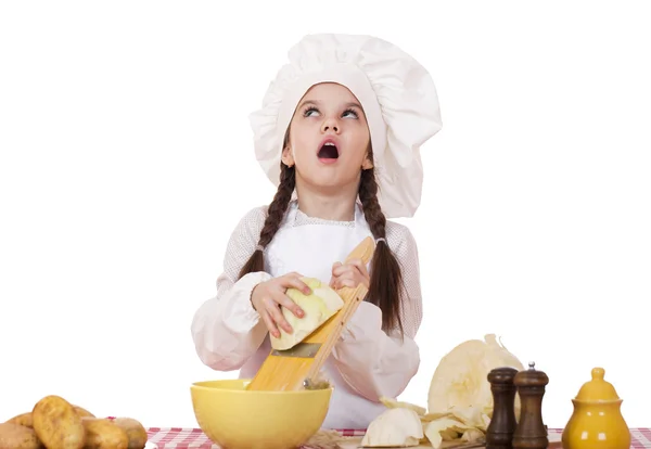 Portrait of a little girl in a white apron and chefs hat shred c — Stock Photo, Image