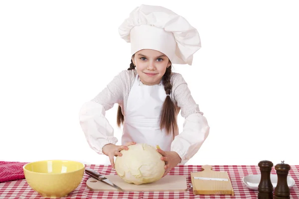 Portrait of a little girl in a white apron and chefs hat shred c — Stock Photo, Image
