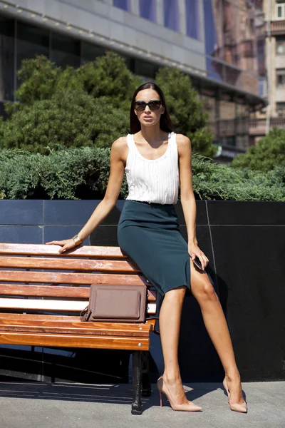 Beautiful business woman sitting on a bench — Stock Photo, Image