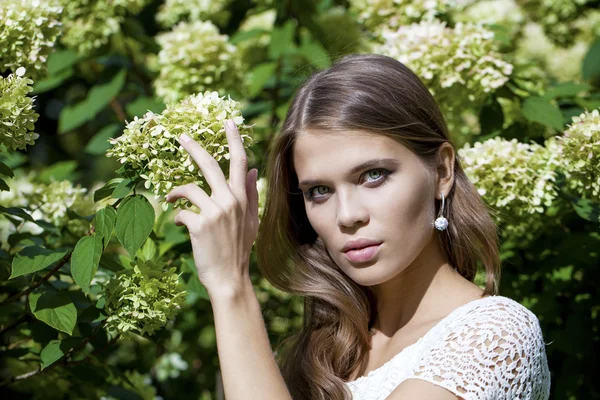 Portrait of beautiful young brunette woman in spring blossom — Stock Photo, Image