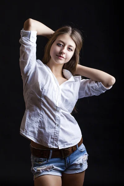 Portrait young girl in a blue jeans jacket and shorts in dark st — Stock Photo, Image