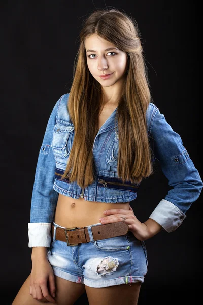 Retrato menina em uma jaqueta jeans azul e shorts em st escuro — Fotografia de Stock