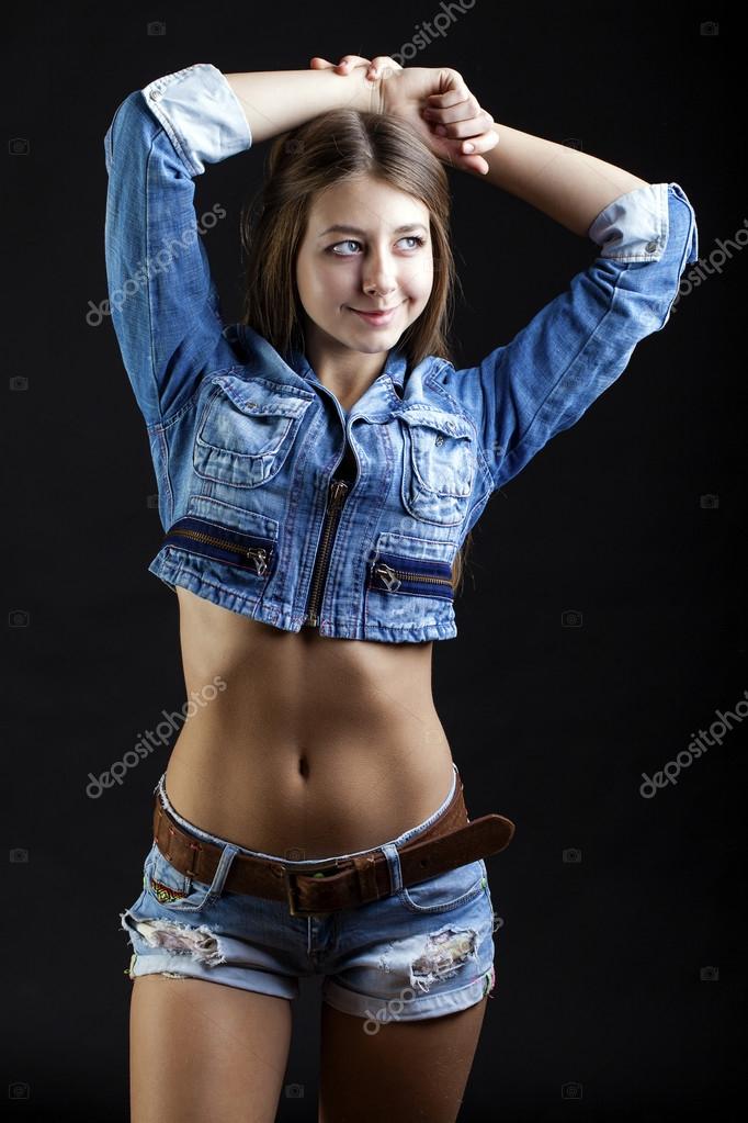 Portrait young girl in a blue jeans jacket in dark studio — Stock Photo ...