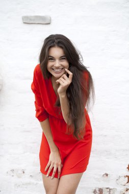 Mutlu genç kadın bir blok arka planı Kırmızı elbiseli