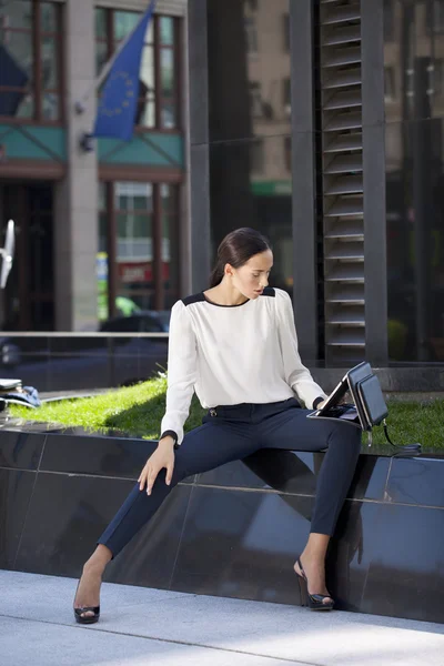 Schöne Geschäftsfrau sitzt auf einer Bank — Stockfoto