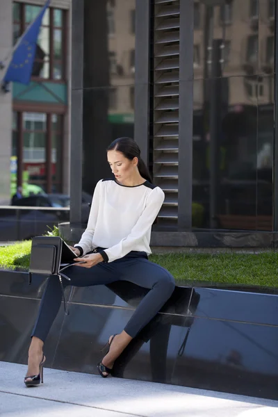 Beautiful business woman sitting on a bench — Stock Photo, Image