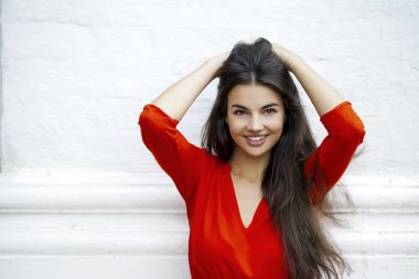 Mutlu genç kadın bir blok arka planı Kırmızı elbiseli