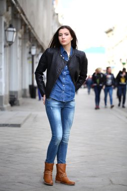 Genç güzel kız mavi kot pantolon ve backg üzerinde mavi bir gömlek