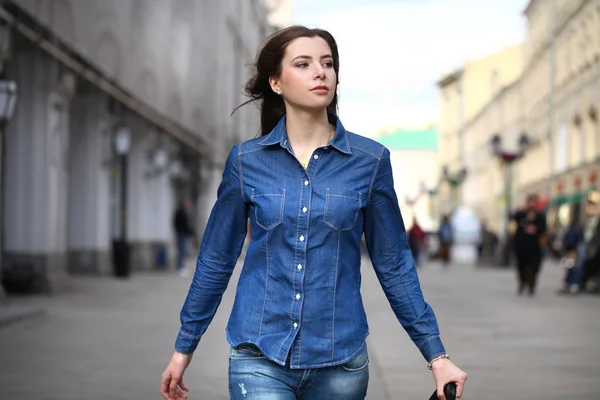 Πορτρέτο του μια όμορφη νεαρή γυναίκα σε ένα μπλε τζιν πουκάμισο εμπό — Φωτογραφία Αρχείου