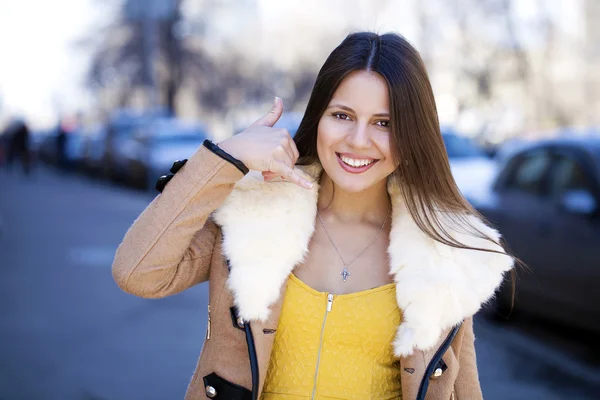 Beautiful happy brunette woman making a call me gesture — Stock Photo, Image