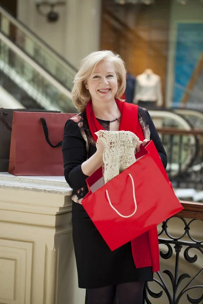 Reife, glückliche Frau mit Einkaufstüten — Stockfoto