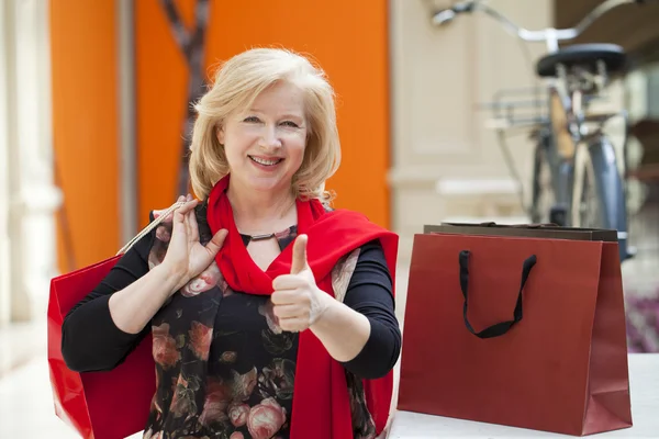 Madura feliz mujer con bolsas de compras —  Fotos de Stock